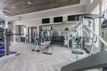 A gym with a variety of equipment including weights and cardio machines.